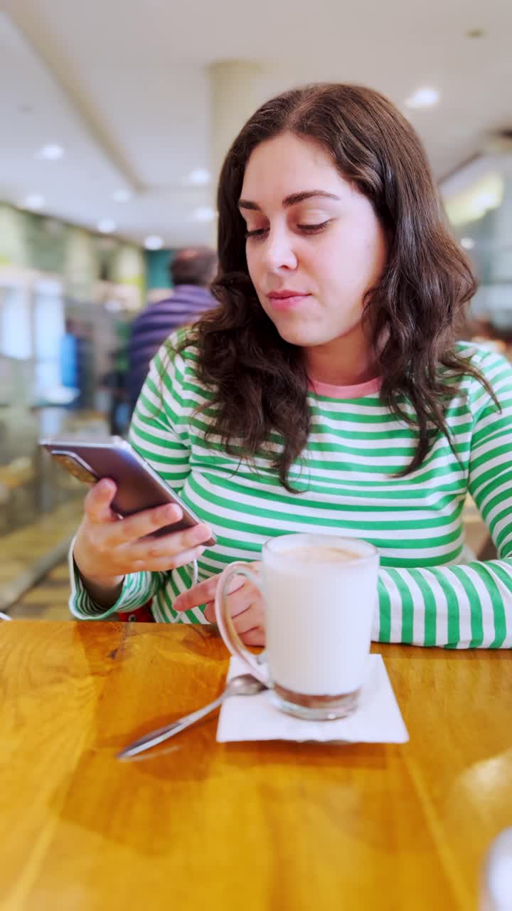 Young woman enjoying a hot beverage at a coffee shop