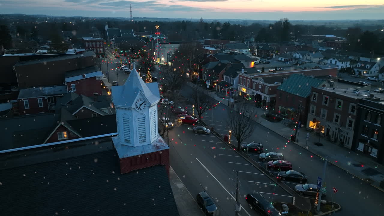밤에 눈보라가 치는 동안 작은 마을의 교회 시계탑
