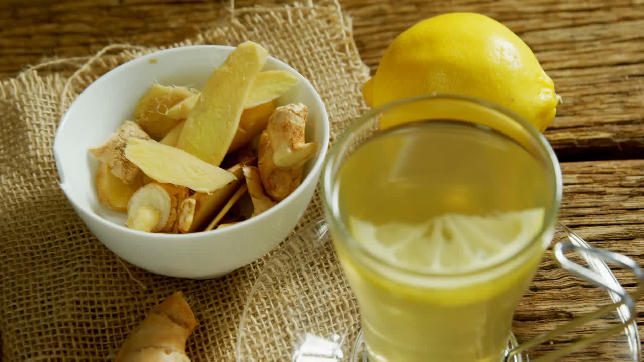 Tè al limone con zenzero e limone su tavolo di legno 4k