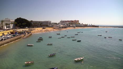 slow cinematic tilt up over boats parked in cadiz harbor at high tide