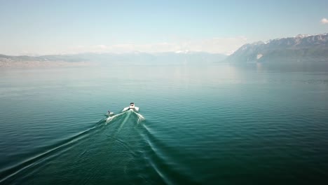 medio del lago de ginebra, con un barco de recreo navegando y cortando el agua