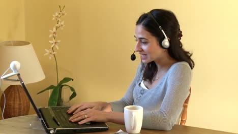 mujer sonriente hablando en internet con auriculares puestos