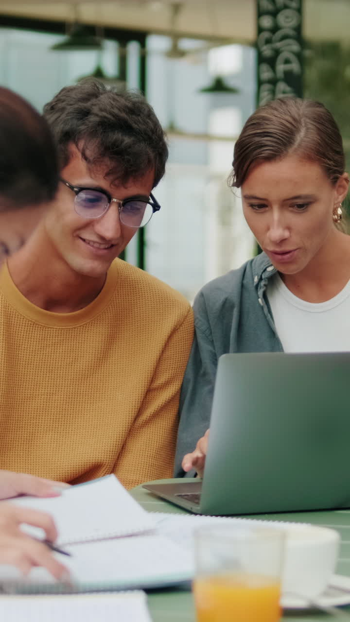 Students of different nationalities use modern technology outdoors, laptop for