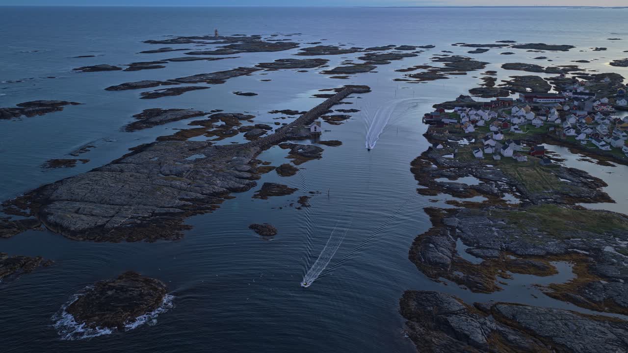 Små båter flyter ved soloppgang ved landsbyen Veiholmen, Smøla, Norge, luftfoto.