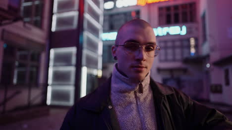 stylish man in neon-lit city at night