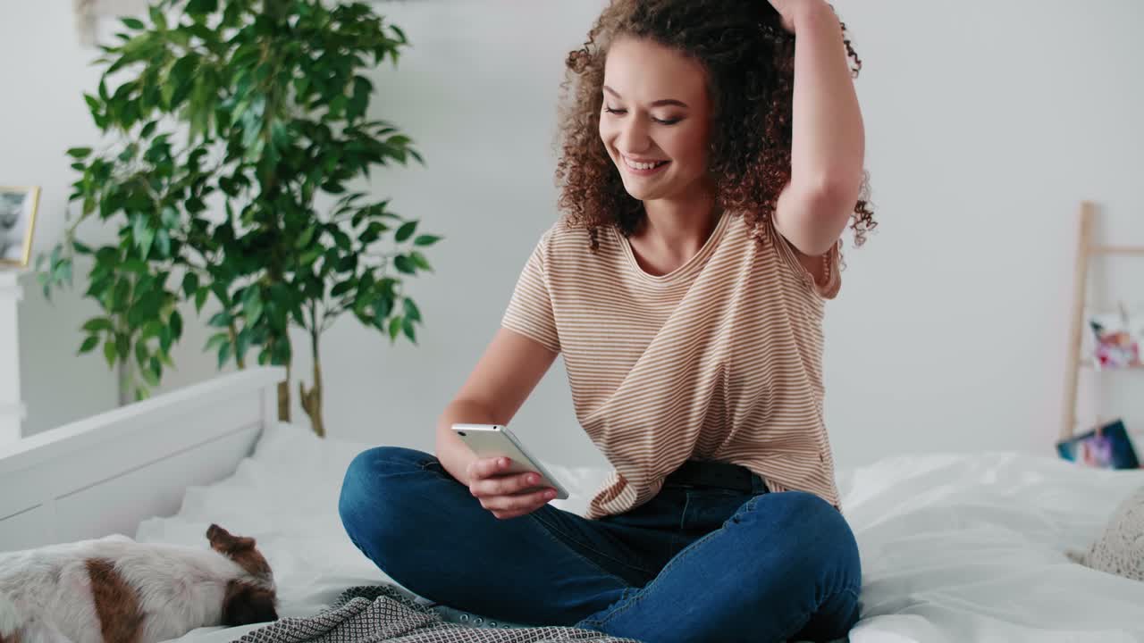 Teenage girl using mobile phone in her bedroom