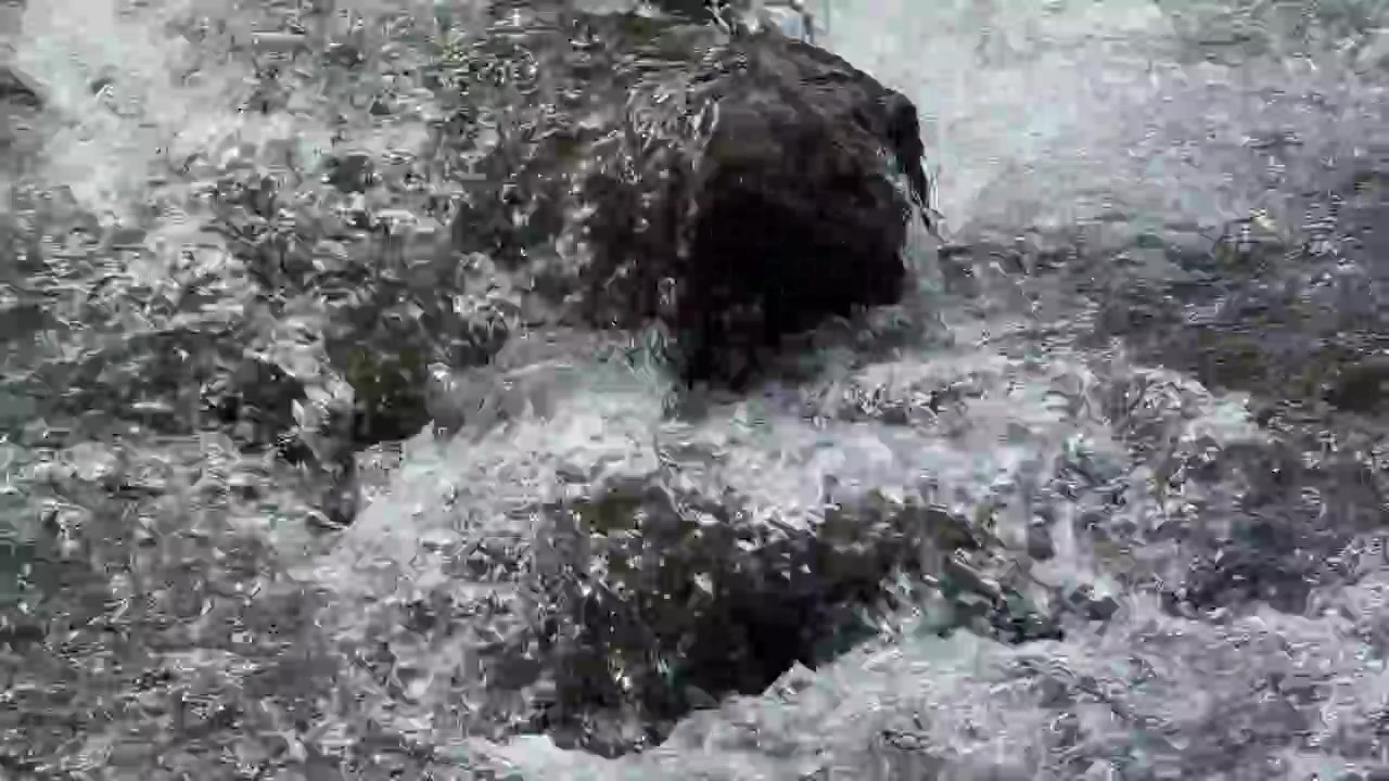 Acqua limpida che scorre sopra rocce scure del fiume