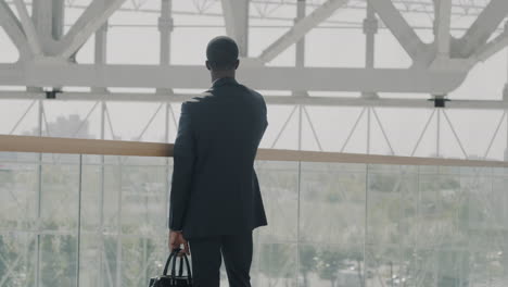 businessman looking at cityscape from balcony