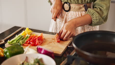 woman chopping colorful bell peppers