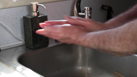 a man washing his hands rubbing with soap for at least twenty seconds for coronavirus prevention