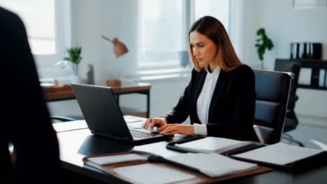 mujer de negocios trabajando en una computadora portátil en la oficina