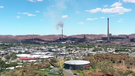 Excelente-Toma-Aérea-Del-Tráfico-Cerca-De-Las-Chimeneas-De-Un-Centro-Industrial-En-Mount-ISA,-Australia