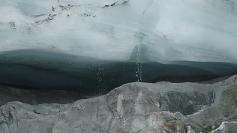 water dripping down from ice in a glacier lake at brewster track in mount aspiring national park, new zealand