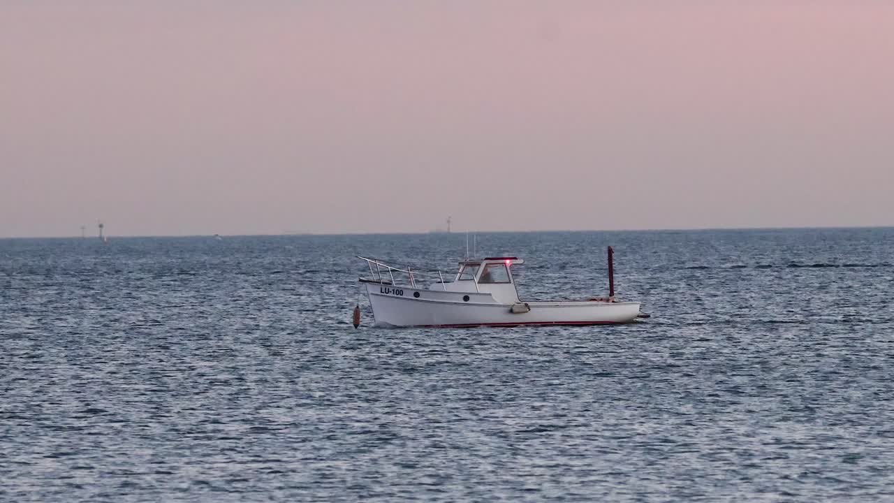 해가 지면 바다를 가로질러 움직이는 배