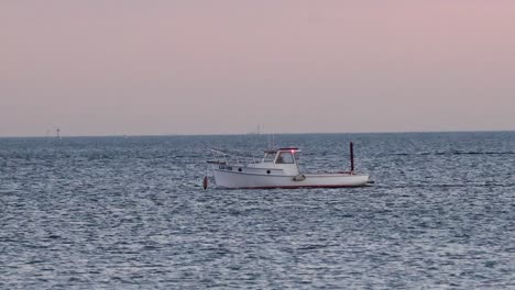 un barco moviéndose a través del océano al atardecer