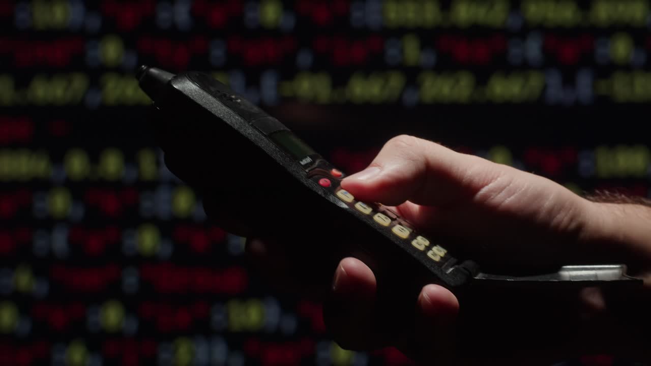 persona marcando un teléfono celular antiguo