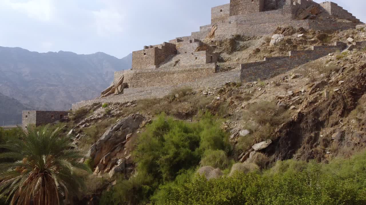 vista aérea frente a la aldea de zee aayn, en la soleada arabia saudita - en aumento, disparo de un dron