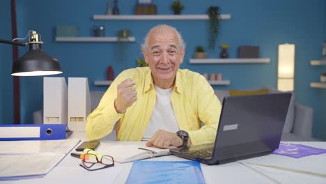Home-office-worker-old-man-getting-good-news-from-camera.
