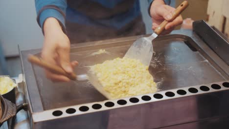 a taiwanese street food vendor grills cheesy corn to perfection, blending creamy toppings with smoky flavors in a bustling night market setting