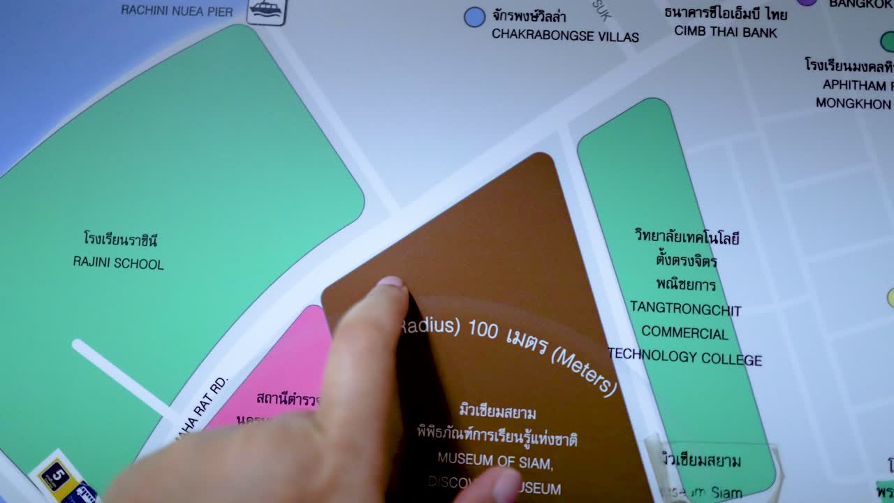 A hand interacts with a digital map of Bangkok, highlighting various locations. Bright lighting and close-up shots emphasize the details