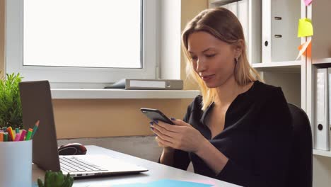 mujer de negocios enviando mensajes por móvil en el interior