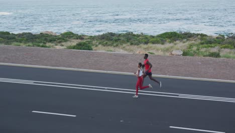 Pareja-Diversa-En-Forma-Haciendo-Ejercicio-Corriendo-En-Una-Carretera-Rural-En-La-Ladera-De-Una-Montaña