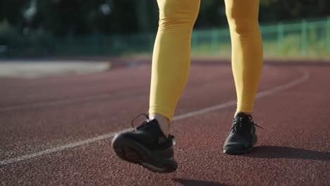 female athlete running on outdoor track in sportswear