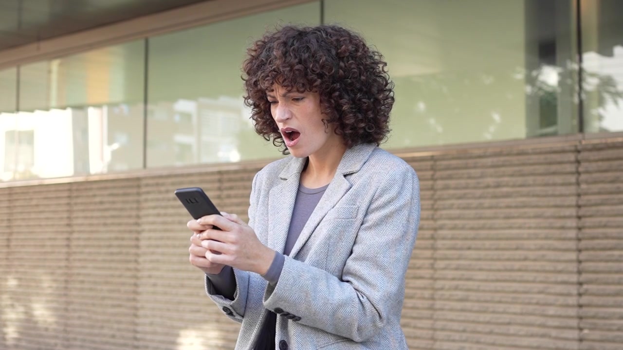 Una donna d'affari usa il suo smartphone all'aperto, mostrando il suo approccio dinamico alla comunicazione.