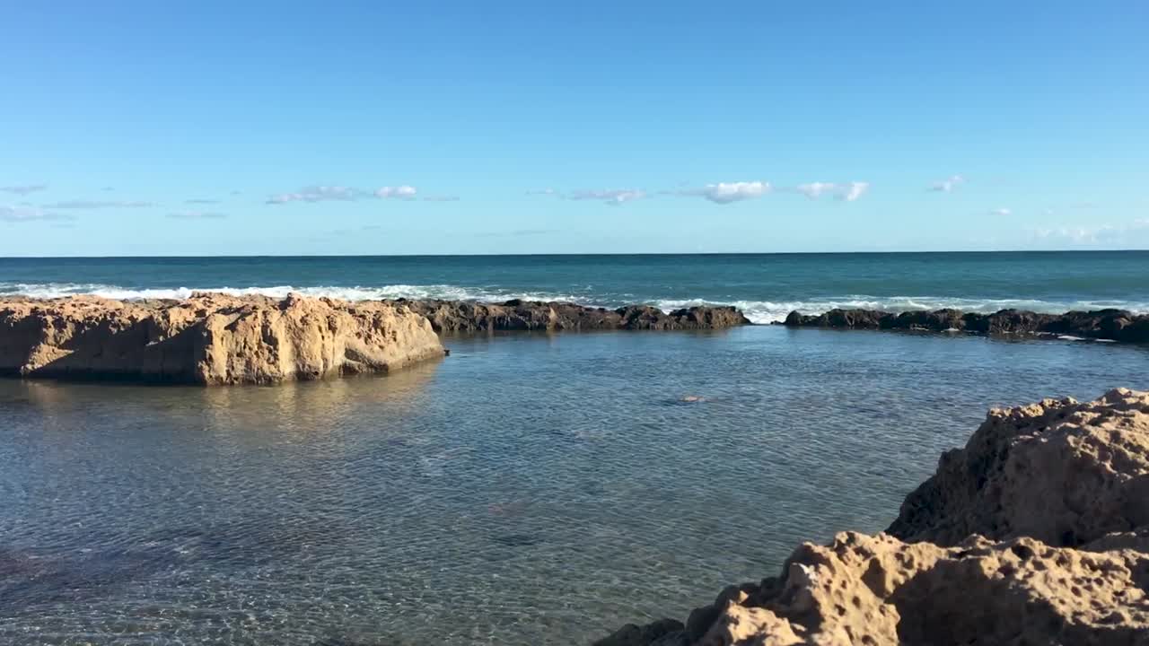 olas rompiendo en piscinas de roca en el mar