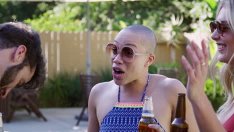 group of smiling friends outdoors making a toast with beer and enjoying summer pool party