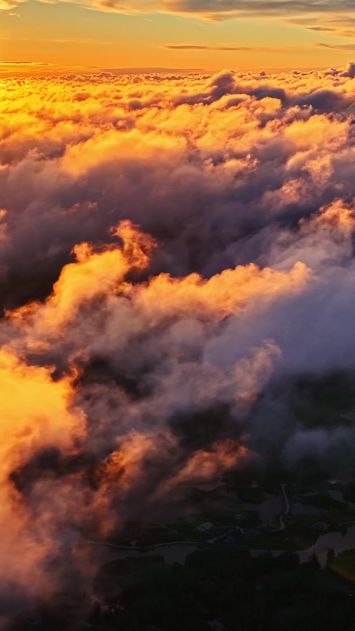 Bright orange sunset lighting dramatic cloud formations above the sky.