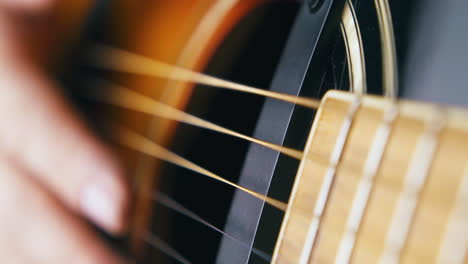 hand beats brown acoustic guitar body setting pace closeup