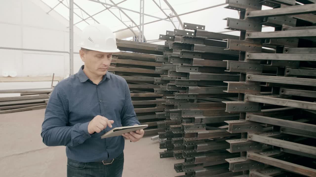 Engineer inspecting metal beams in a warehouse