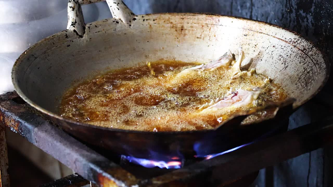 Frittura in sequenza di pesce in una padella su fiamma