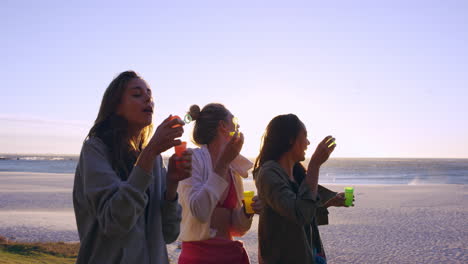 group of pretty girls blowing bubbles at sunset