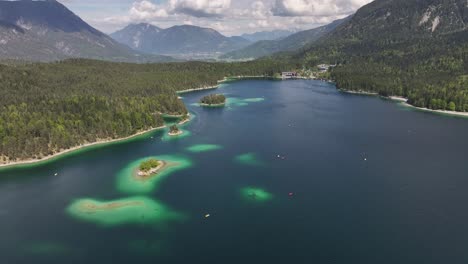 Vista-Aérea-De-Eibsee,-Grainau,-Alemania,-Que-Muestra-Aguas-Turquesas,-Costas-Boscosas-Y-Un-Telón-De-Fondo-Montañoso.