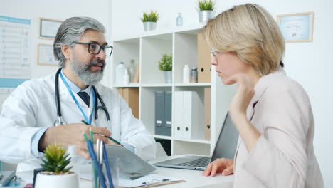 el médico discutiendo los registros médicos con el paciente