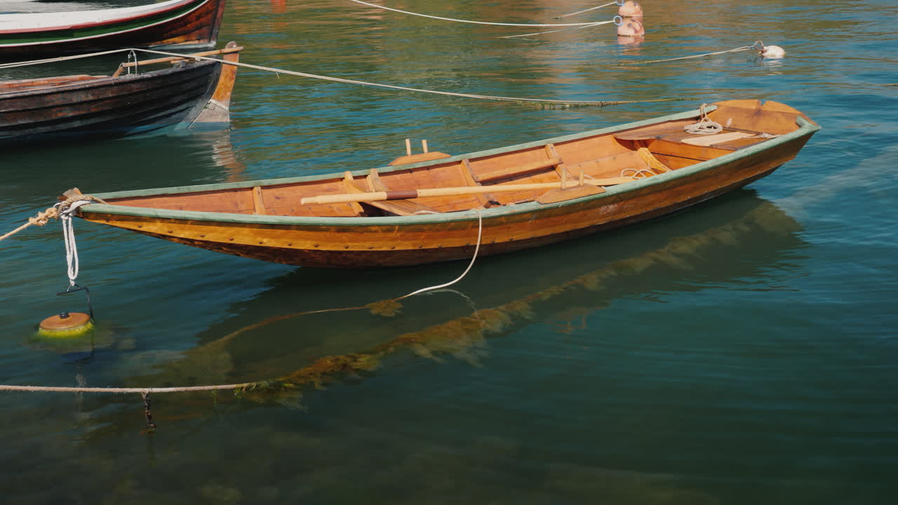 un pequeño barco de pesca de madera se mece en las olas cerca de la orilla 4k video