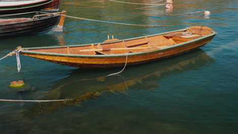 a small wooden fishing boat rocks on waves near the shore 4k video