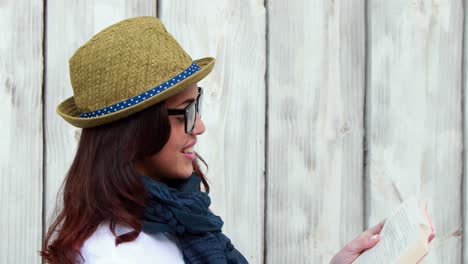 una mujer hipster sonriente leyendo un libro