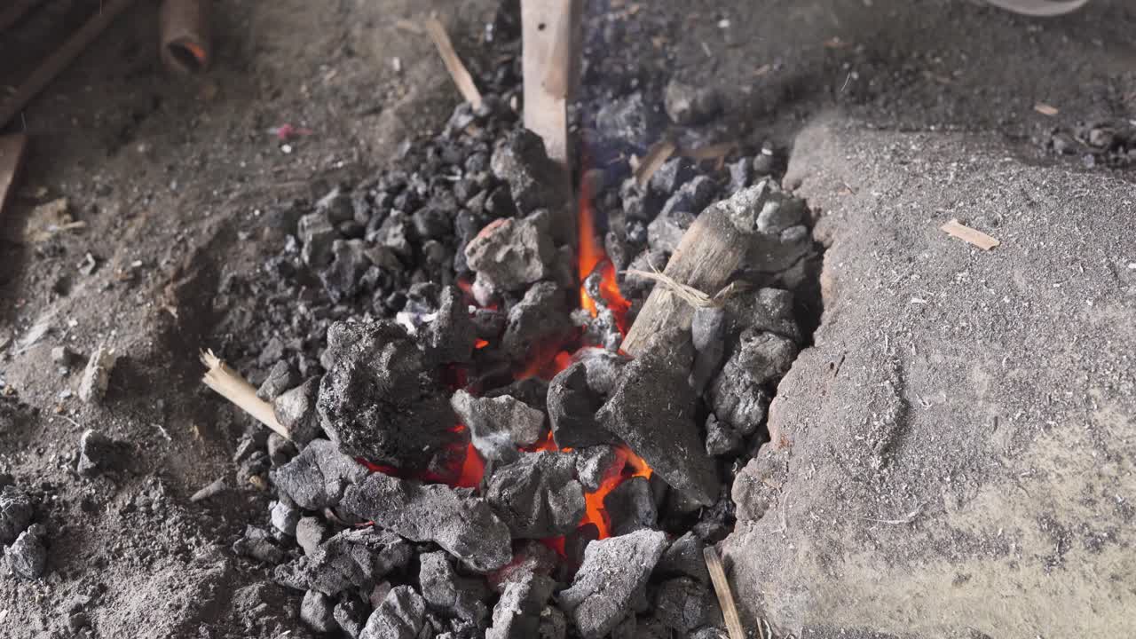 Charcoal heating of cocunut knife for bending by indian blacksmith