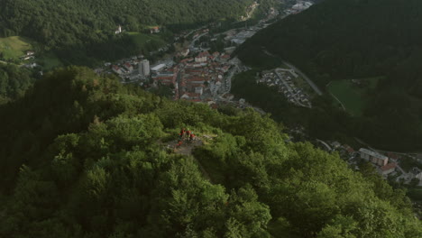 aerial view of town nestled in a valley with hikers on a mountaintop