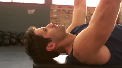 hombre en forma levantando pesas por encima de la cabeza