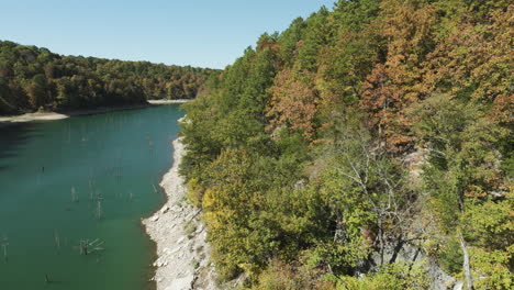 fall foliage on the shore of beaver lake in bland, arkansas, usa