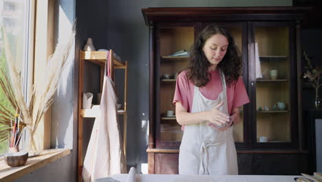 mujer moldeando arcilla en un estudio de cerámica