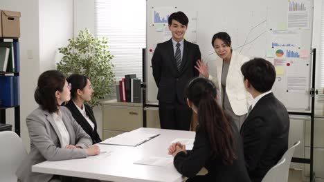 asian businesspeople applauding to congratulate coworker with personal achievement in meeting. female manager praising giving recognition with hand gesture