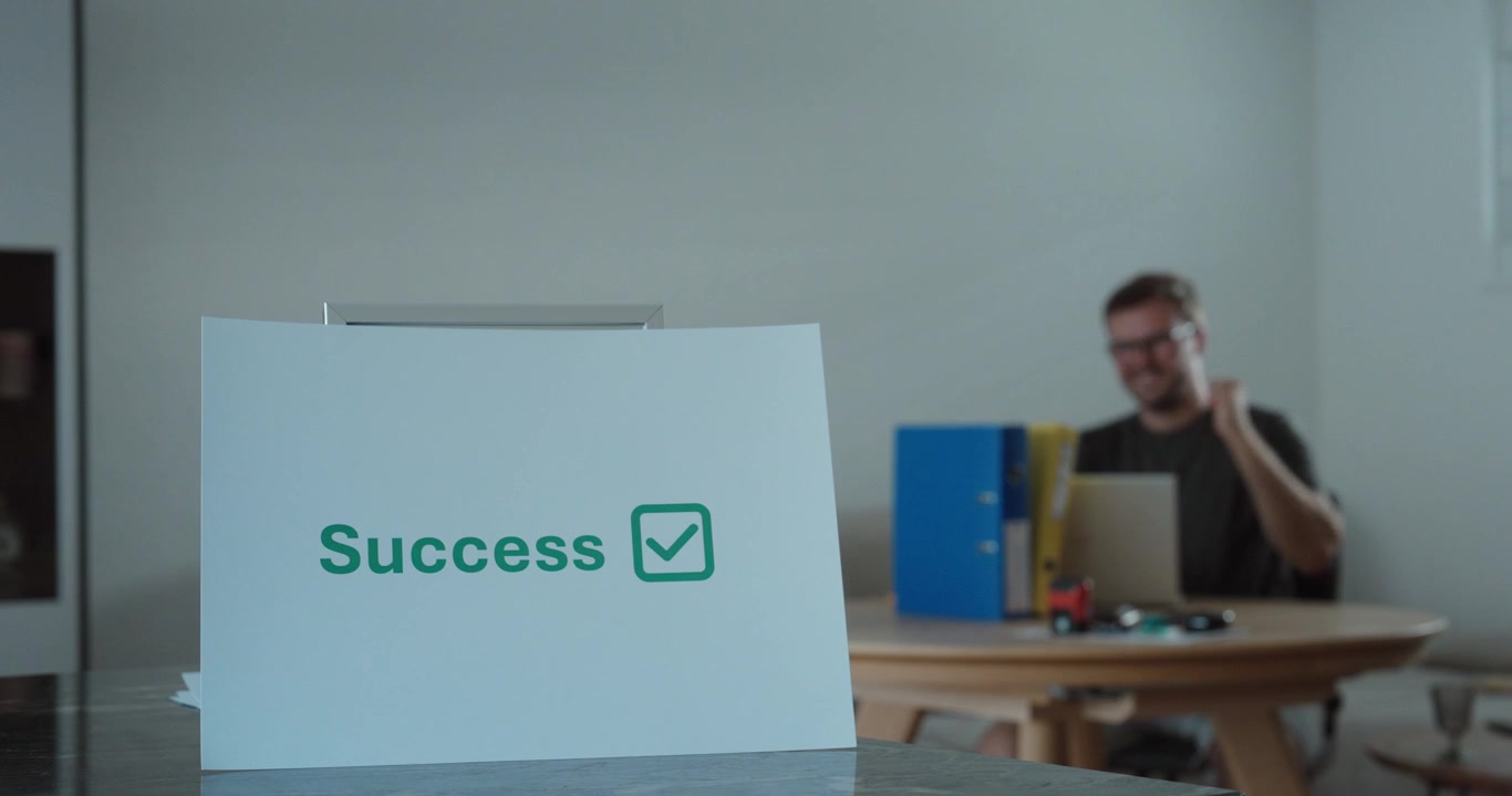 Businessman celebrating success while working on a laptop in a home office. Ideal for business success, productivity, entrepreneurship, and remote work concepts.