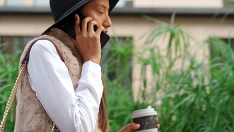 stylish hispanic woman talking on smartphone