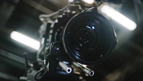 Low-angle-shot-of-a-professional-cinema-camera-and-long-telephoto-zoom-lens,-zoom-motor-is-turning-the-gears-and-the-lens-element-is-moving-to-change-focal-length