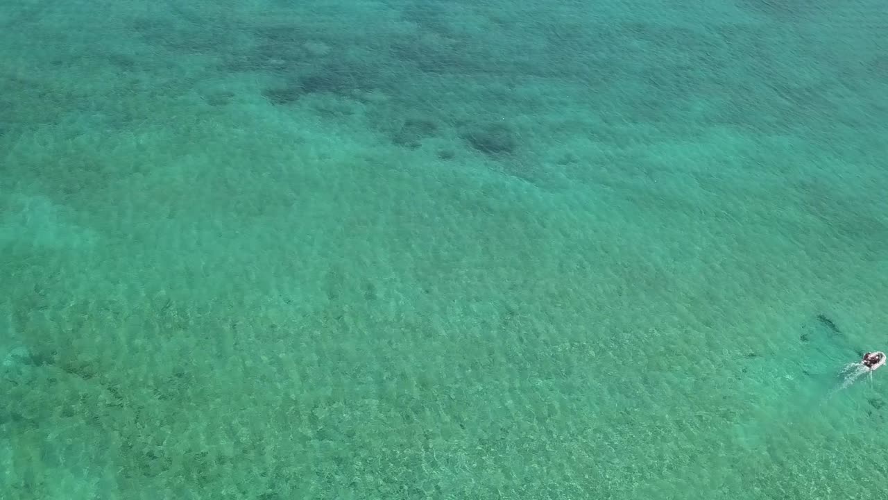 화창한 나소, 바하마 해안의 얕은 물에서 보트를 내려다보는 공중 전망